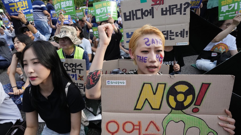 南韓示威者手繪抗議標語寫上「不要污染水」。 美聯社