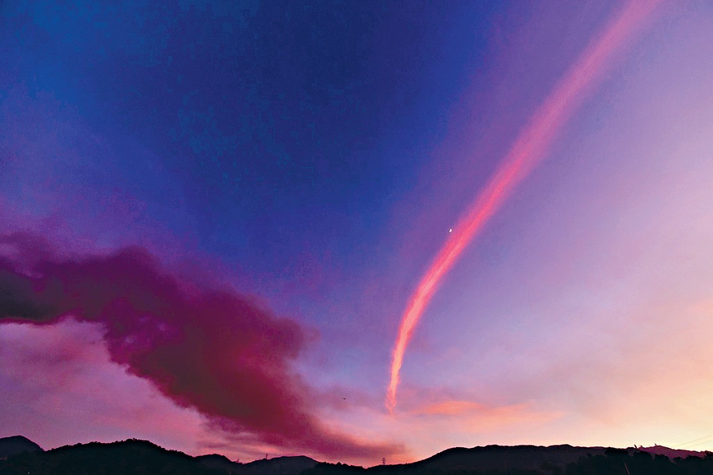 棕灰色火成雲與紅色飛機雲。