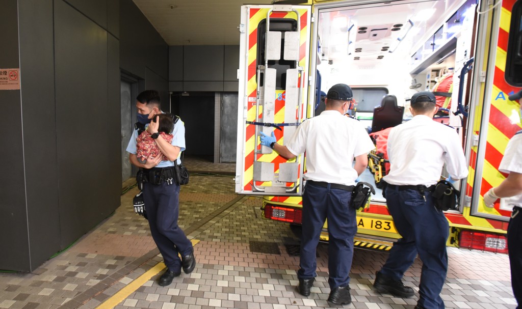 一名嬰兒由警員手抱落白車到醫院檢查。