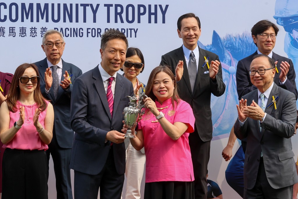文化體育及旅遊局局長羅淑佩（右）於「香港賽馬會社群盃」賽事後，頒發獎盃予頭馬超開心的馬主胡超倫（左）。賽事頒發的獎盃已有超過170年歷史，由收藏家雷剛捐贈，以表揚馬會對社會的貢獻。