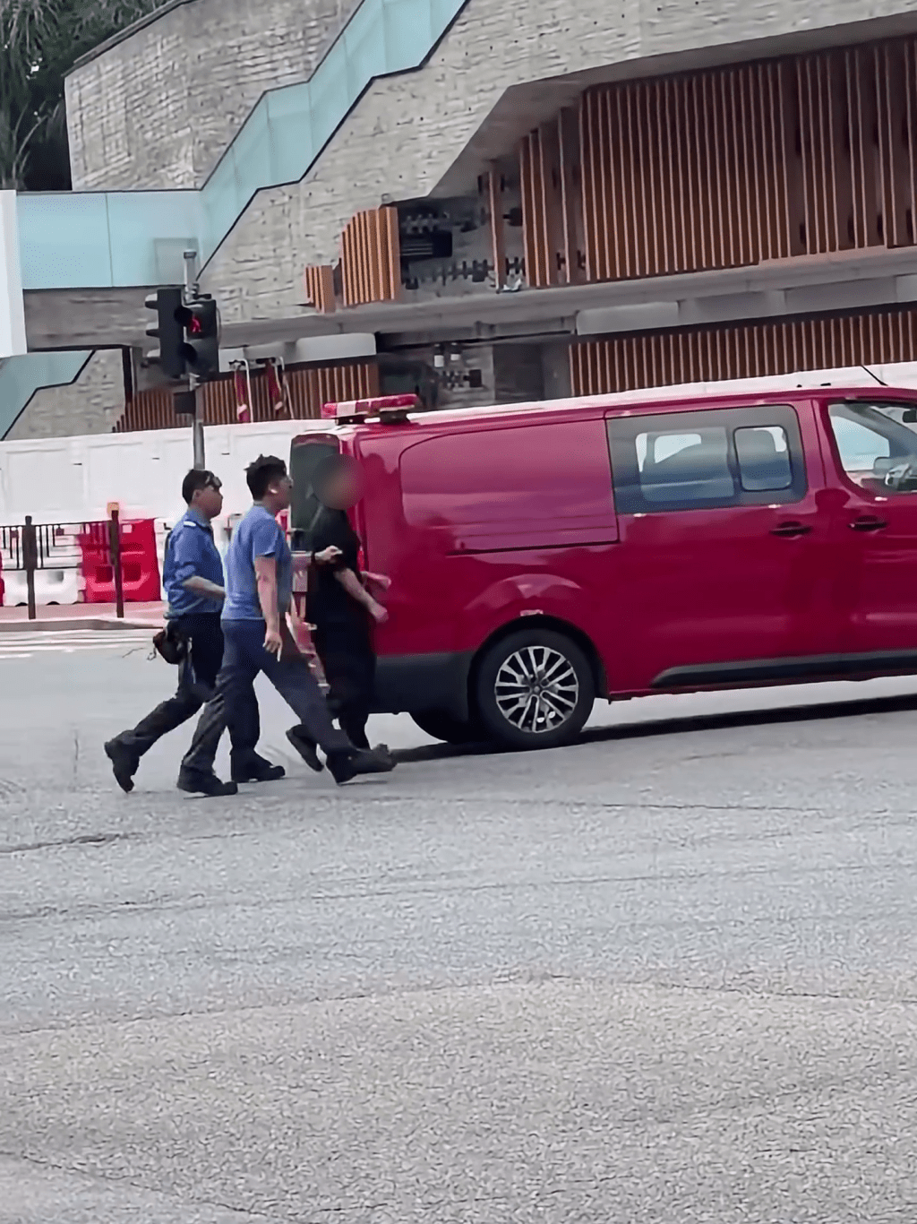 消防員和食環人員將男子帶返行人路。