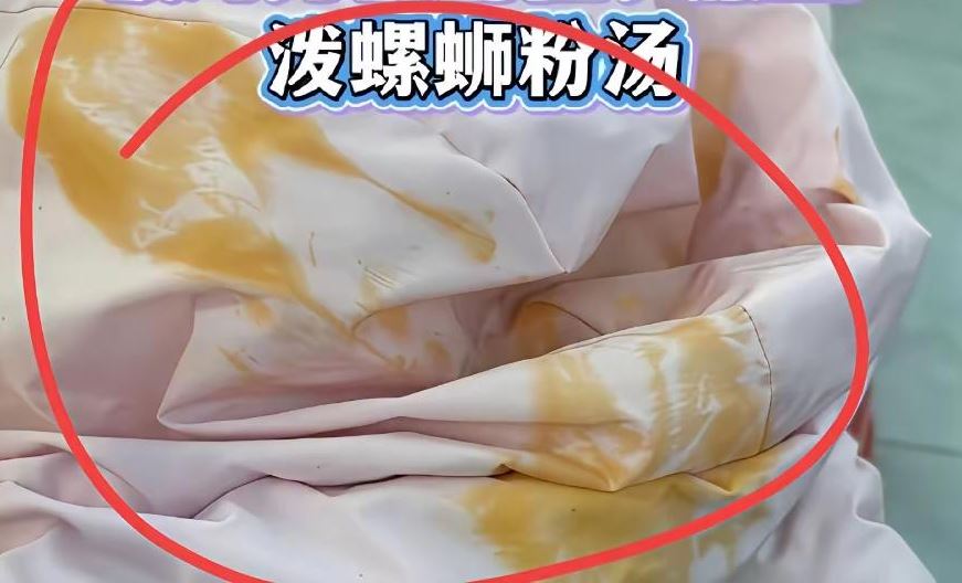 缺德黑衣女將螺螄粉湯倒入背座的羽絨衣帽內。