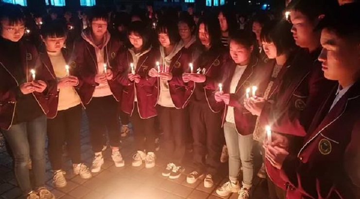 全校學生在教學樓前圍成一圈，點燃蠟燭，為犧牲的學長默哀3分鐘。