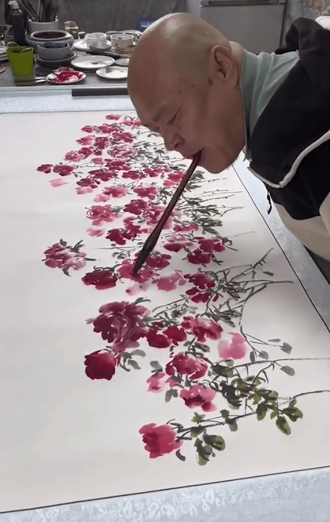 自幼因觸電失去雙臂的黃國富繪製了99朵玫瑰花送給妻子。