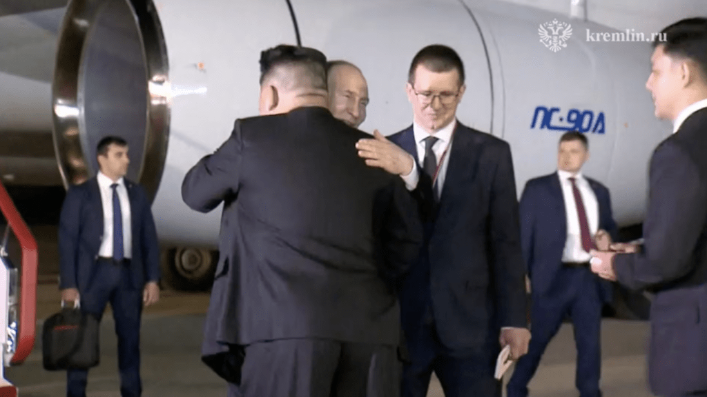 北韓領導人金正恩到機場迎接，兩人見面後即握手擁抱。路透社