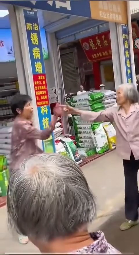 白发老妇与邻人起争执时，连续6次摆出“开枪”手势。抖音@月亮好物分享