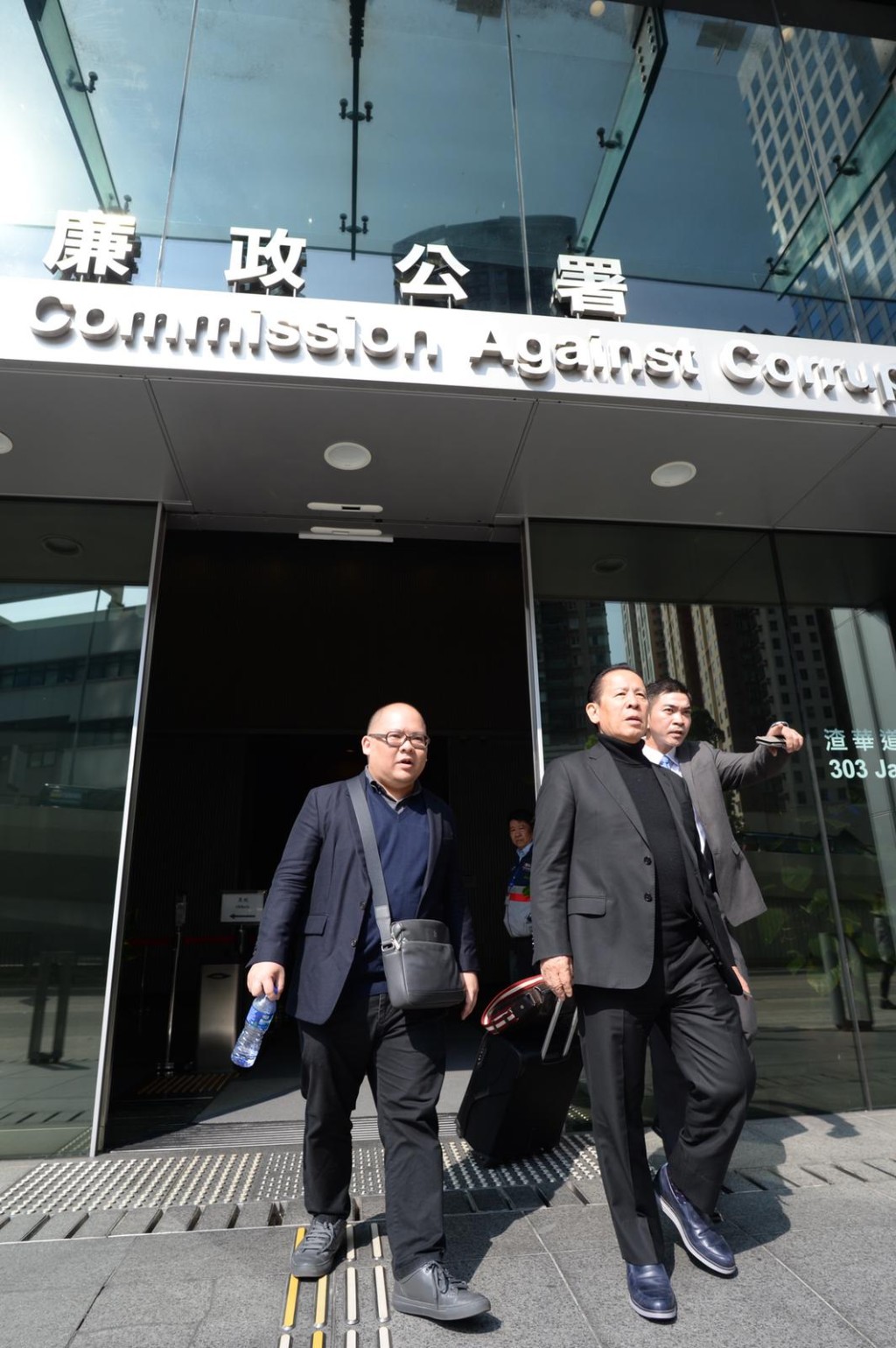 岡田和生(中)到廉署總部,辦理撤銷保䆁手續、獲無條件釋放。