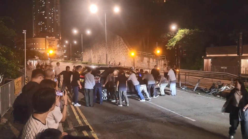 大約有30名熱心市民與警員合力將私家車推回慢線,讓後方的車輛可以通過。fb「屯門公路塞車關注組」Cherubim Cole片段截圖 大約有30名熱心市民與警員合力將私家車推回慢線,讓後方的車輛可以通過。fb「屯門公路塞車關注組」Cherubim Cole片段截圖