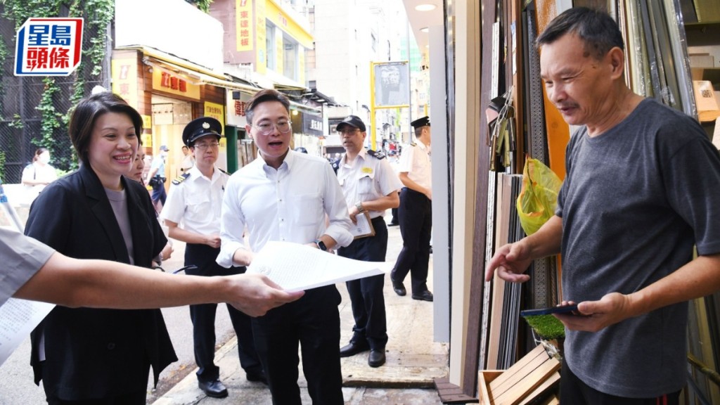 油尖旺區議員黃舒明與食環署落區派發宣傳單張,並提醒店舖不要阻街。 何健勇攝