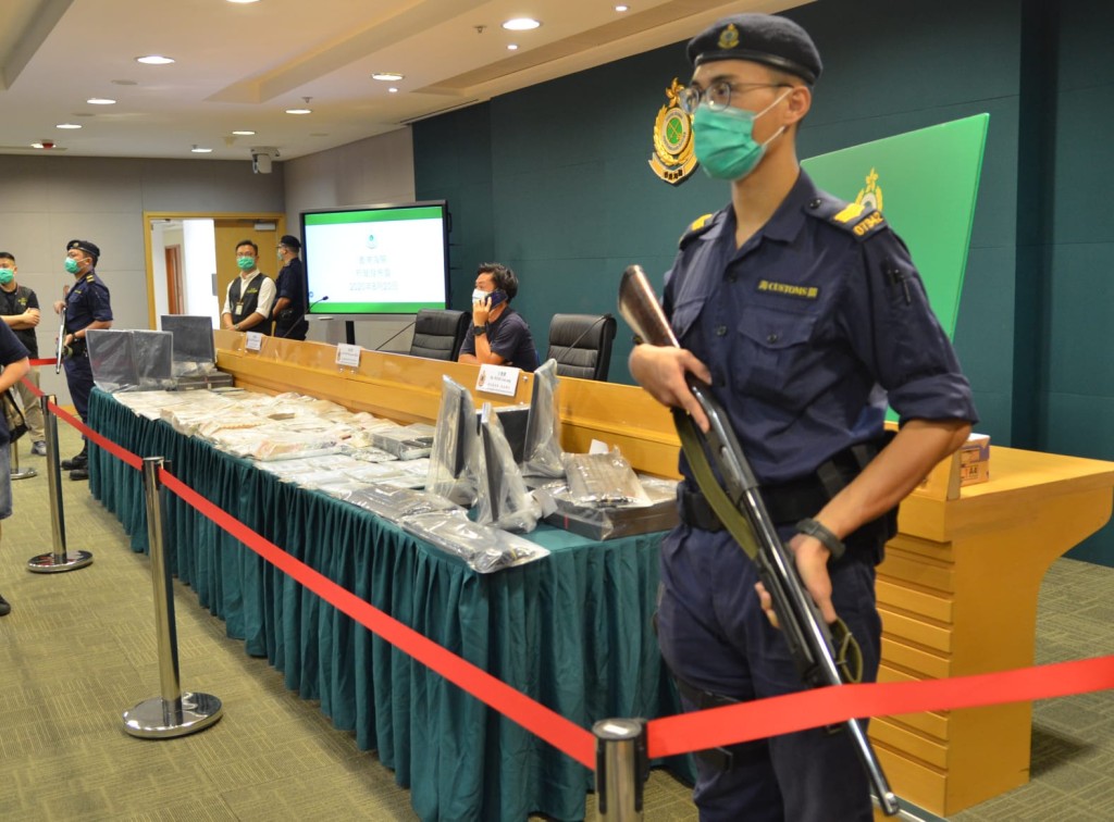 海关罕见手持长枪关员站在证物枱两旁。