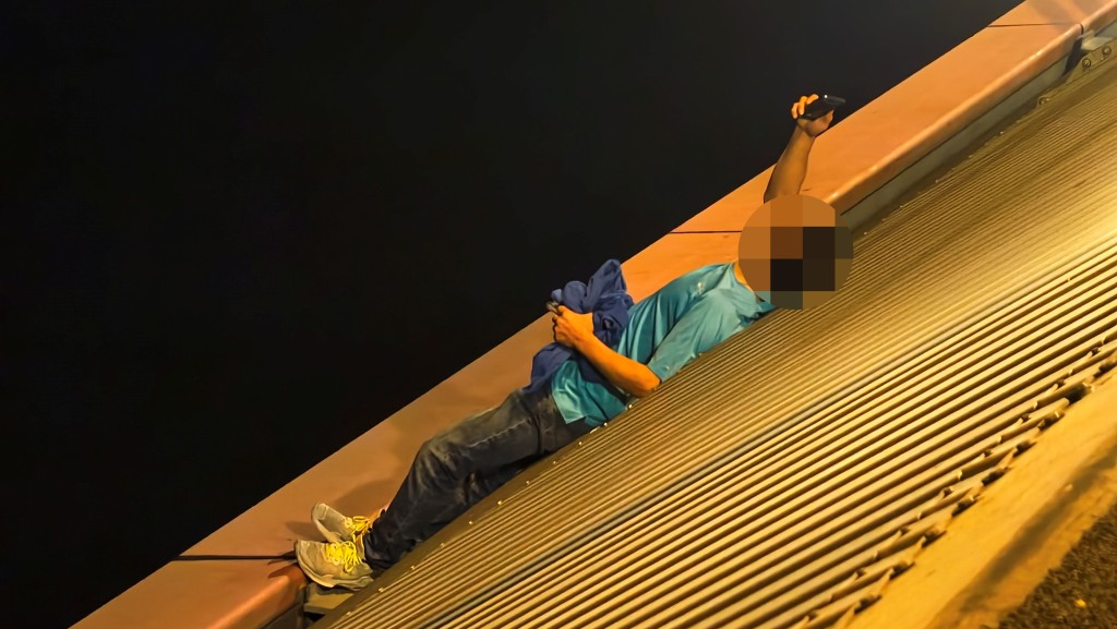 男子不時舉手機拍攝橋面的救援人員及傳媒。