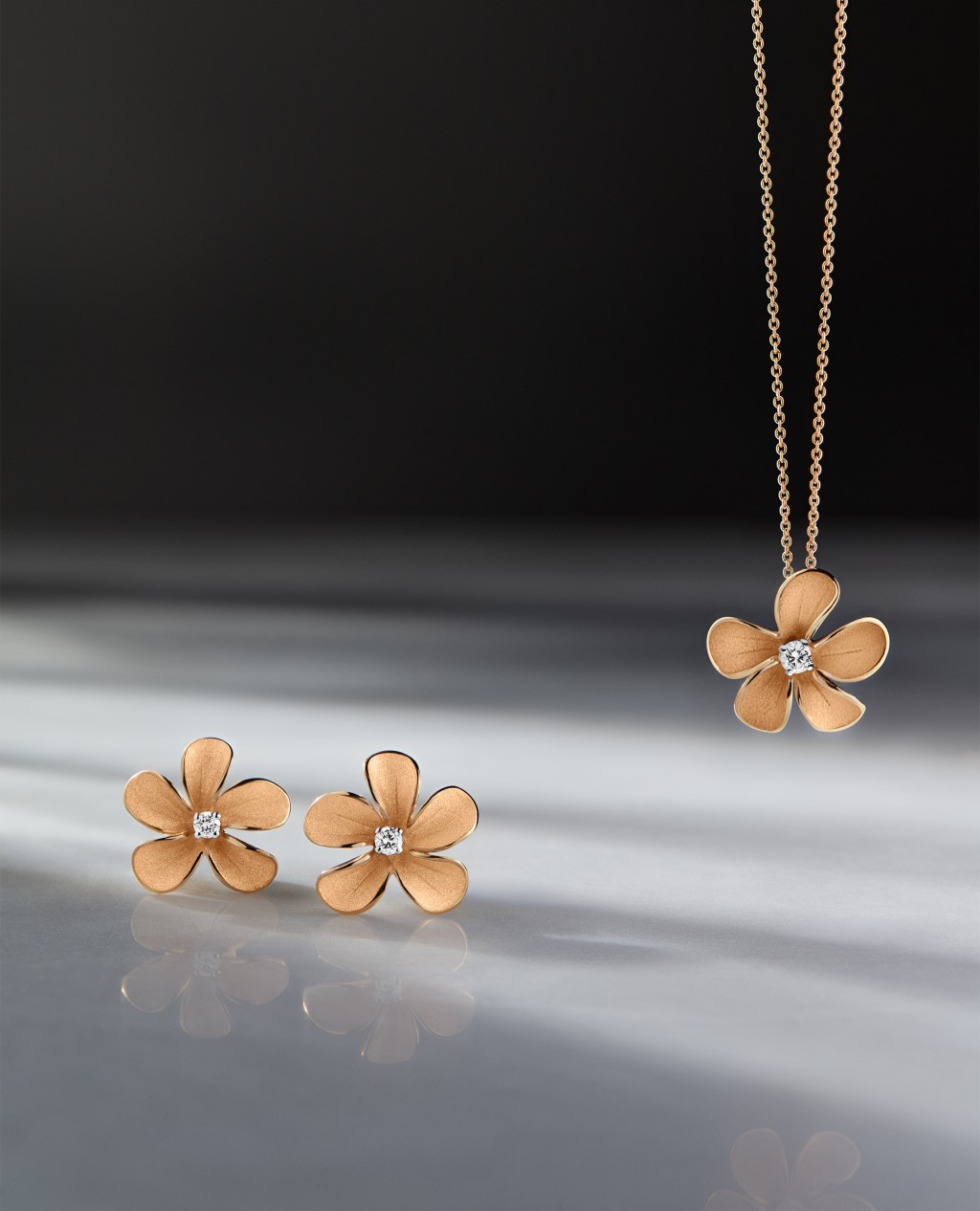 Cherry Bloom系列 展现樱花美态，包罗 18K晨光淡黄色金钻 石颈链（$25,000）、 指环（$19,300）及耳 环（$15,400）。