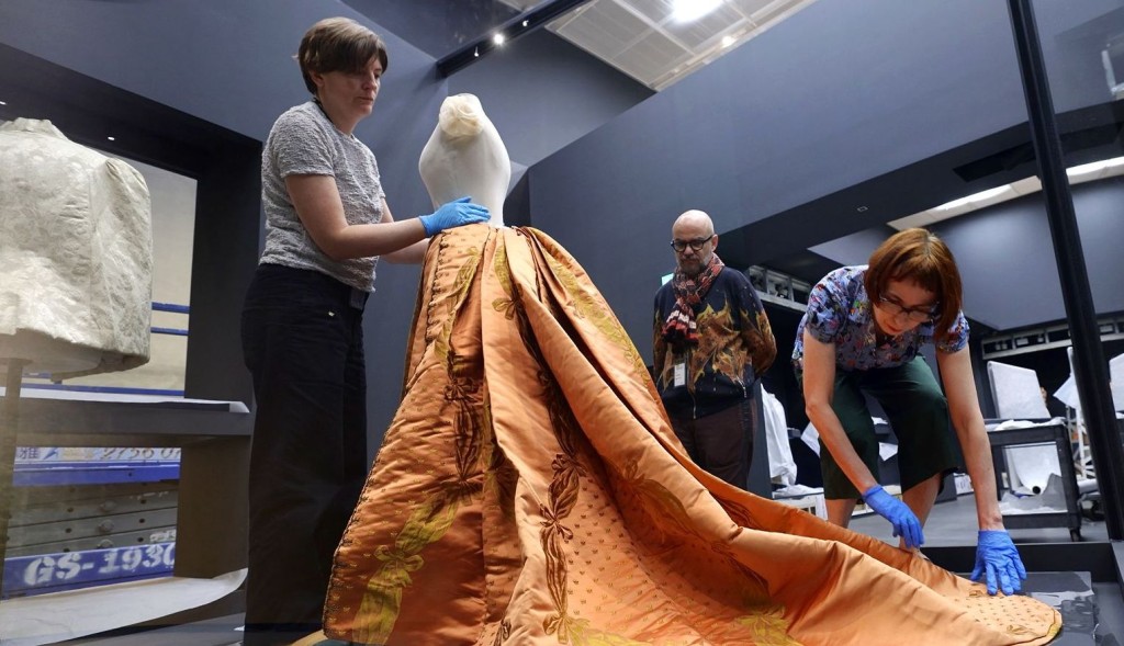 香港故宮文化博物館與巴黎裝飾藝術博物館的布展團隊一起安裝Charles Frederick Worth所設計的長裙（約1885年）。