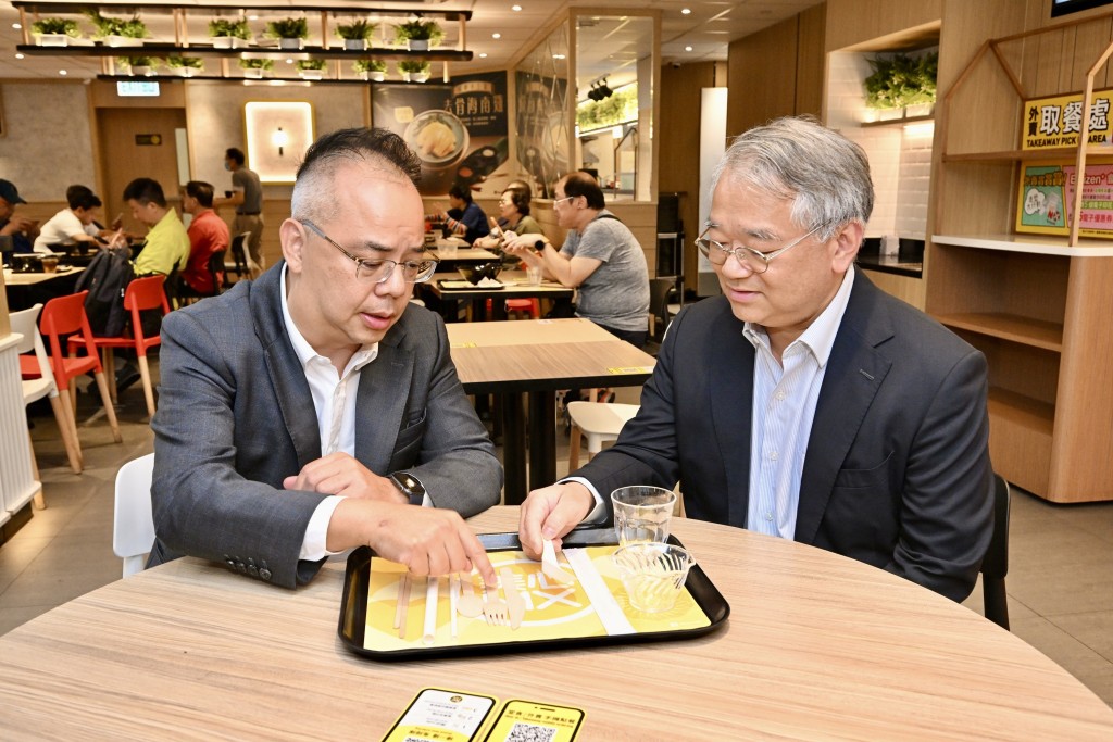 徐浩光(右)与餐厅负责人倾谈，了解餐厅提供的替代品餐具。政府新闻处图片