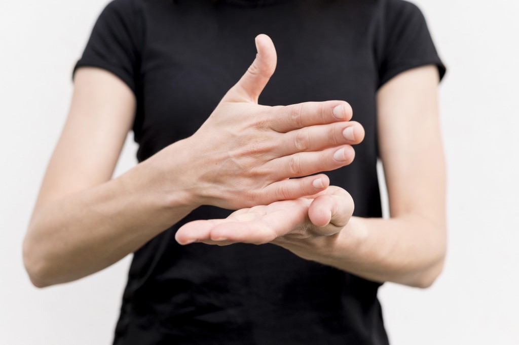 使用手語的聾人在與健聽人士溝通時，常依賴手語翻譯員在旁協助。 資料圖片