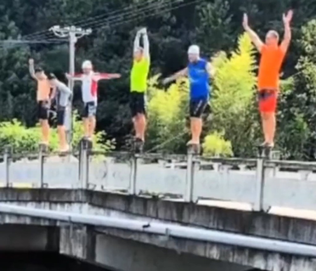 各人站在護欄上準備跳水。《新京報》 各人站在護欄上準備跳水。《新京報》
