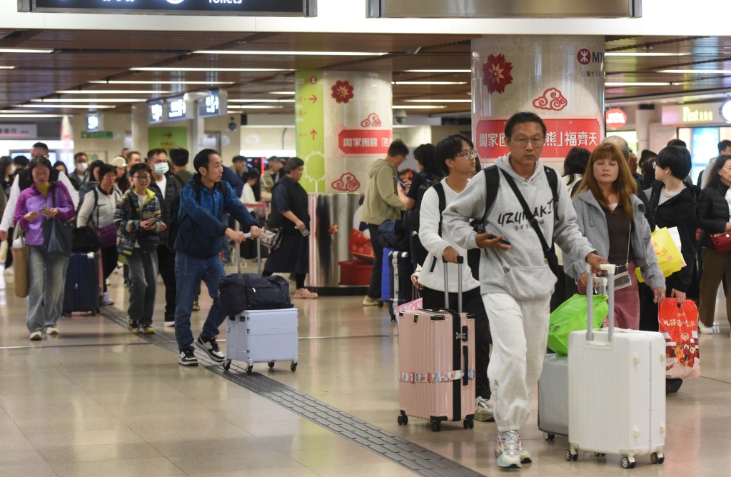 不少人扶老攜幼一家大細「一抽二褦」匆匆返港。黃文威攝