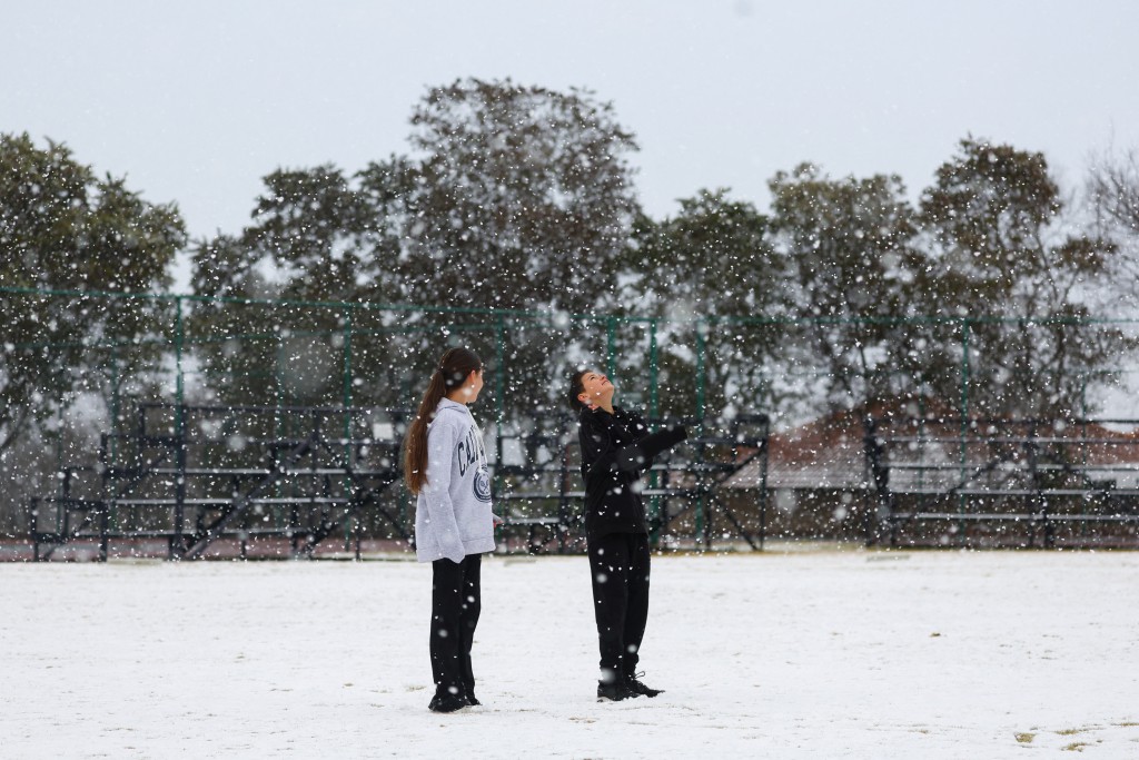 南非豪登省周一迎接2012年以来首场大雪，有小朋友到公园玩雪。  路透社