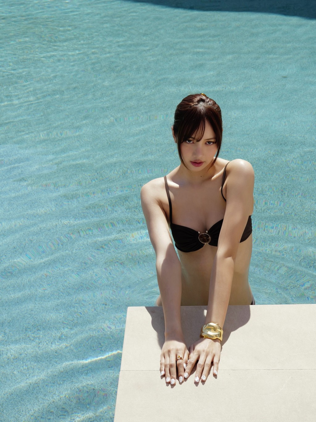 Lisa在泳池邊，眼神望向鏡頭，展現女王氣場。