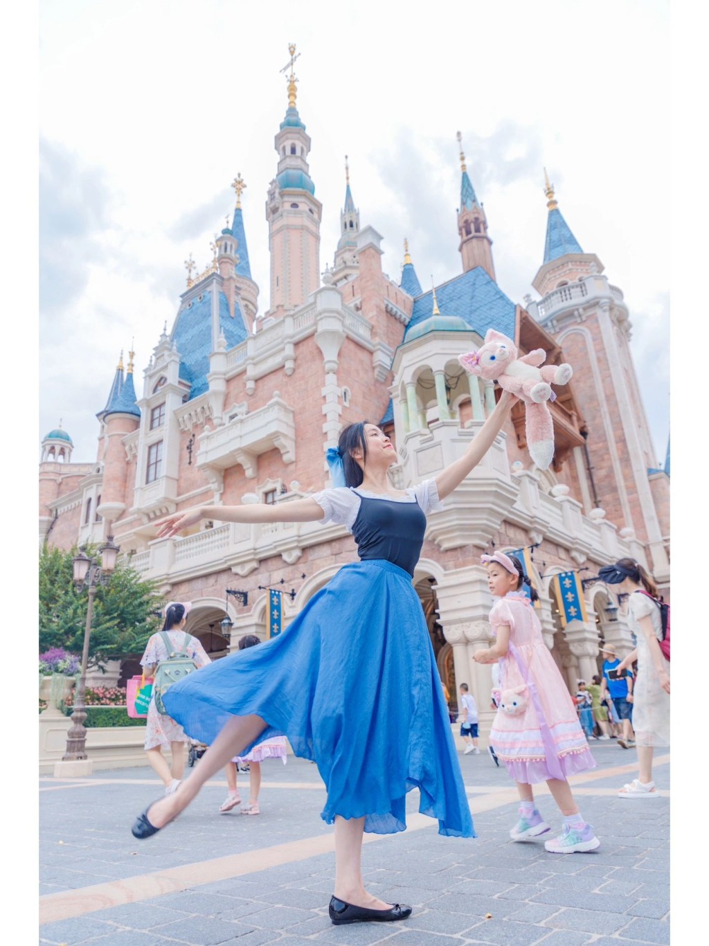 一身公主裝在迪士尼城堡前打卡。