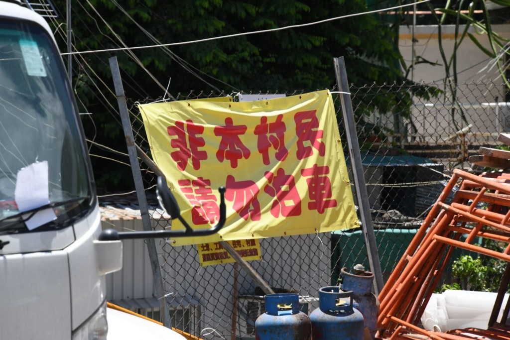 圍網掛有寫上「非本村民,請勿泊車」字句的橫額。