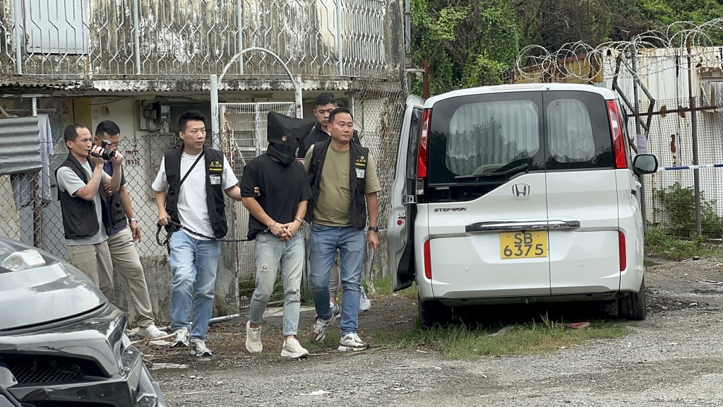 疑犯被押解到毀滅證據的順風圍。梁國峰攝 疑犯被押解到毀滅證據的順風圍。梁國峰攝