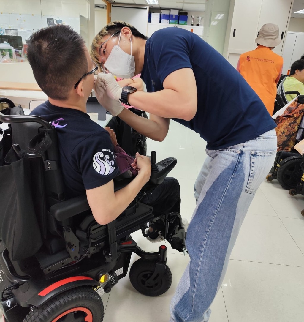獲台灣口腔衞生指導員資格的Mark為病人清潔口腔，讓病人感受何謂輕力刷牙。(受訪者提供)