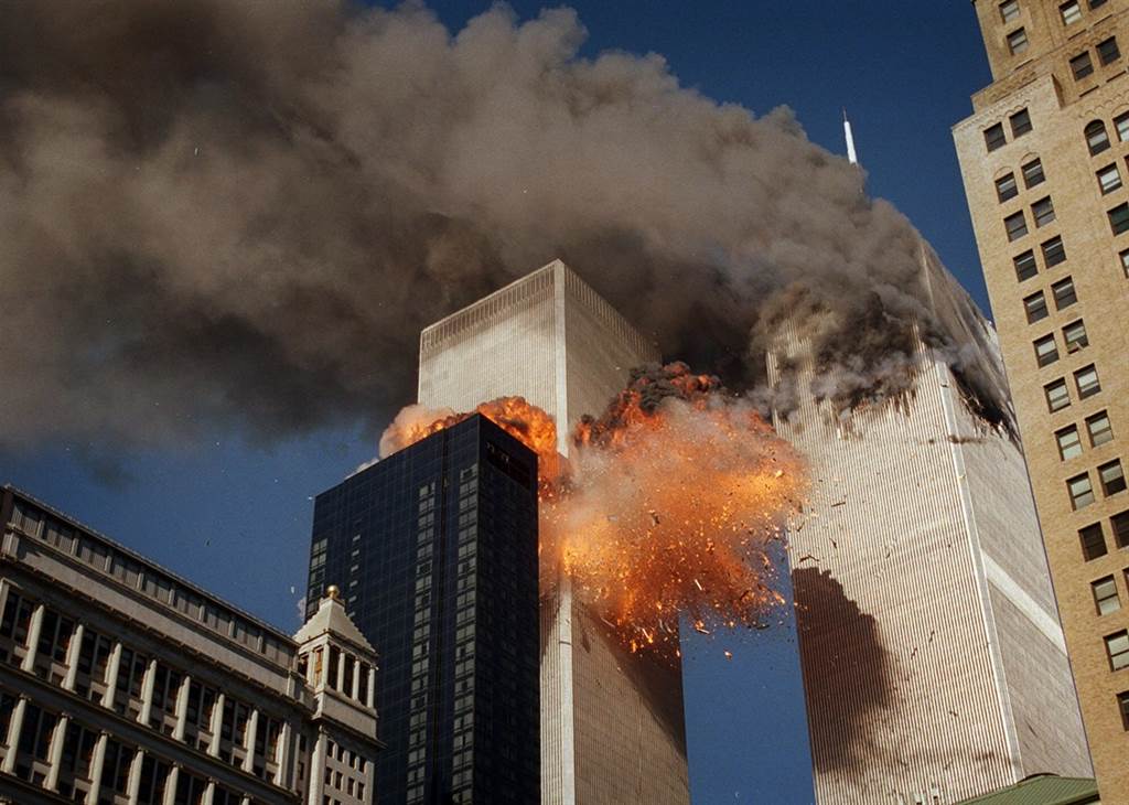 飞机撞上双子塔大楼后，火焰及残骸从第2栋大楼炸开，大楼冒出浓烟。美联社