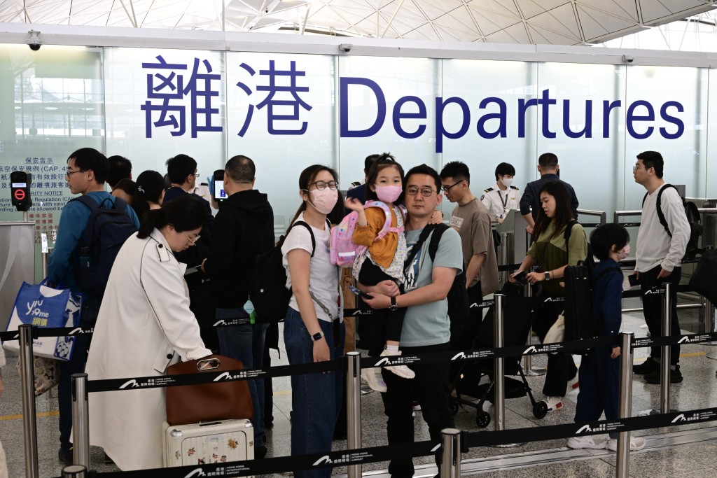 機場的登機櫃台和出境位置等待人龍水泄不通。陳極彰攝
