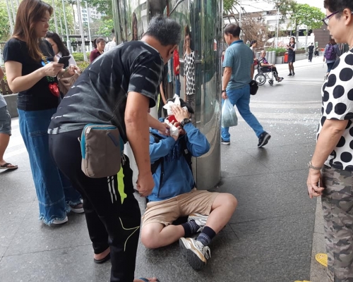 男傷者坐在地上，途人上前幫忙。  香港突發事故報料區FB/網民The Nini C‎圖