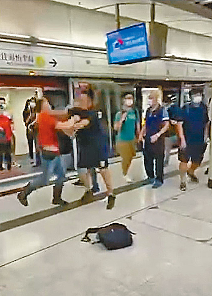 兩男子在月台上爭執打鬥。