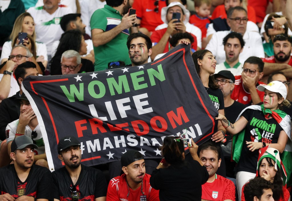 有伊朗球迷高舉「女性、生命、自由」的禁語。路透