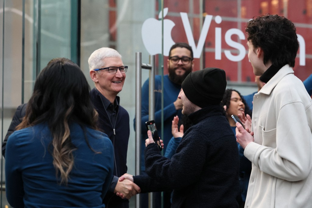 库克在纽约苹果分店和购买产品的顾客握手。路透社