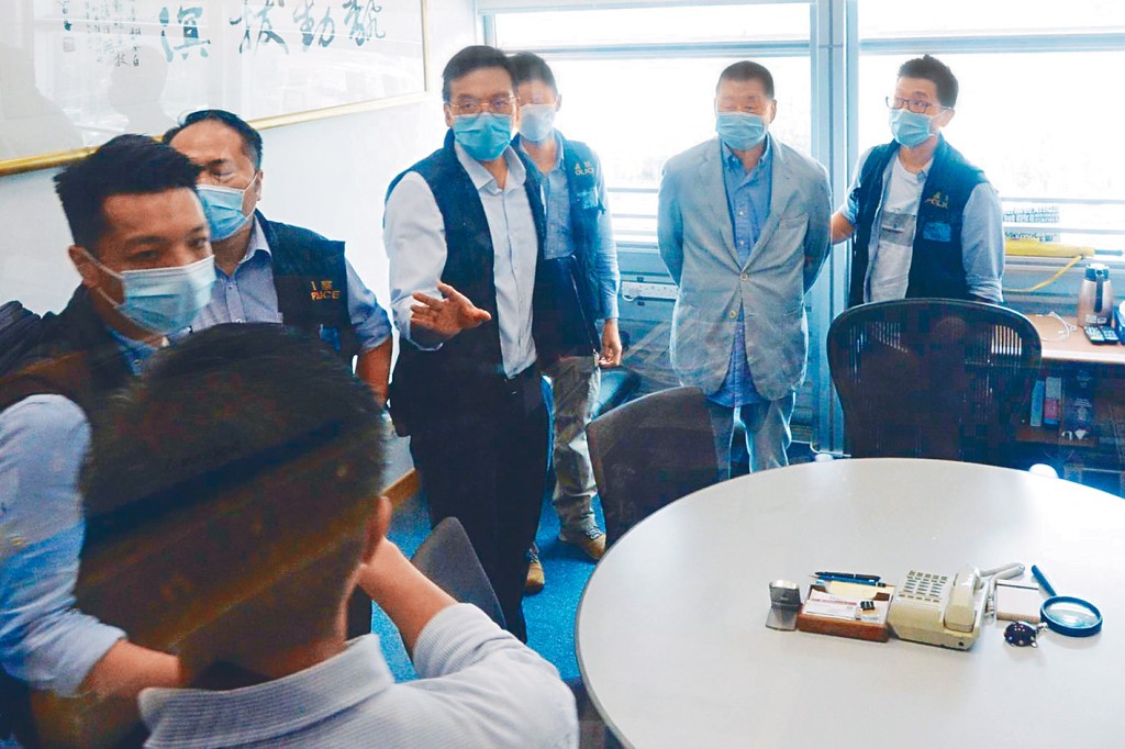 黎智英（右二）被扣上手銬，押返困日報大樓內協助調查。