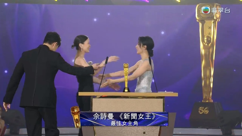 在兩位同期演員手上領取獎項。