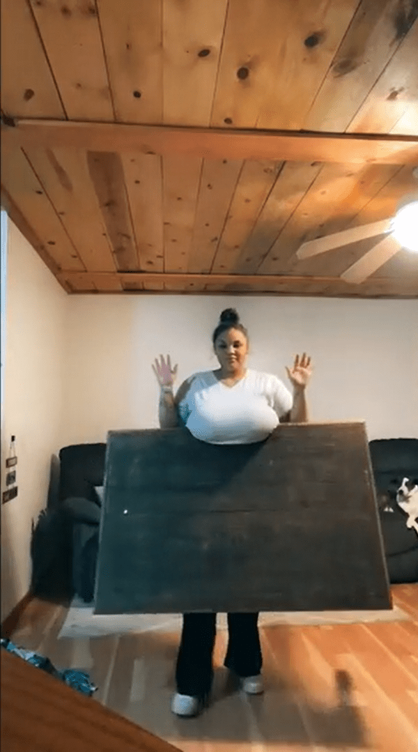 国外女子凯尤娜发起挑战，用惊人巨乳夹住12公斤重的木桌。（截图自TikTok）