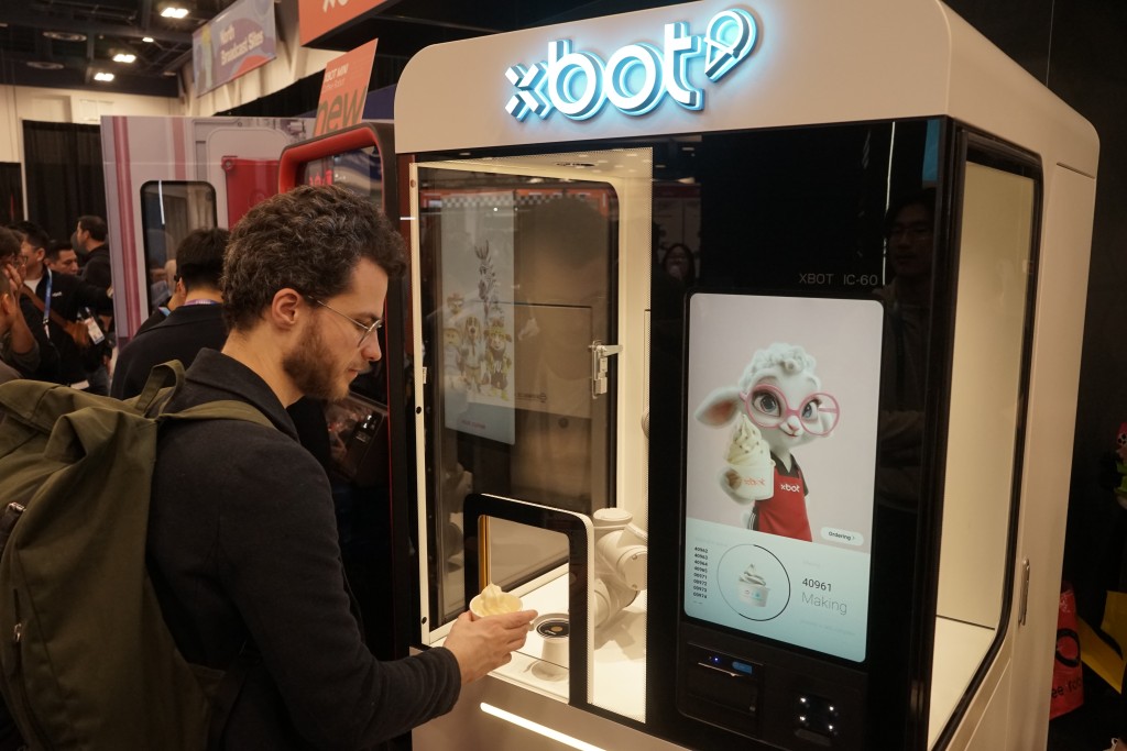 人們在2026年美國拉斯維加斯消費電子展（CES）體驗影智XBOT冰淇淋機械人。 新華社
