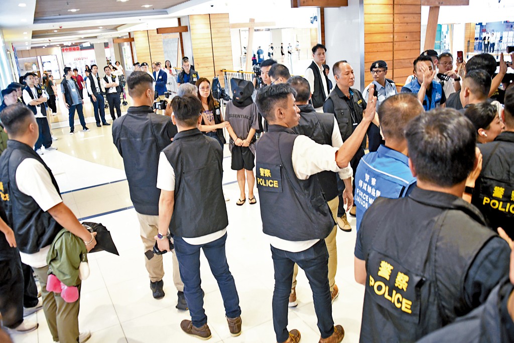 警方昨日上午押解其中一名持雙程證女疑犯到案發現場重組案情,期間模擬疑犯以嬰兒車及行李篋運載男童到參竇過程。