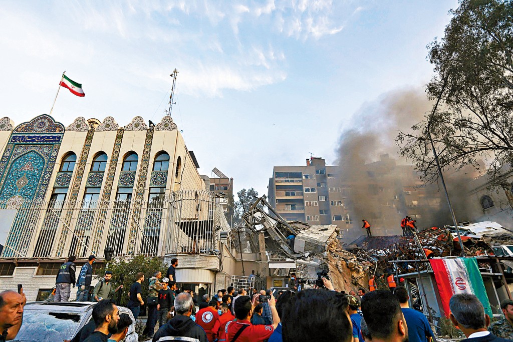 在大马士革，紧邻伊朗大使馆的领事馆大楼周一遭导弹袭击，救援人员在瓦砾堆中搜寻生还者。