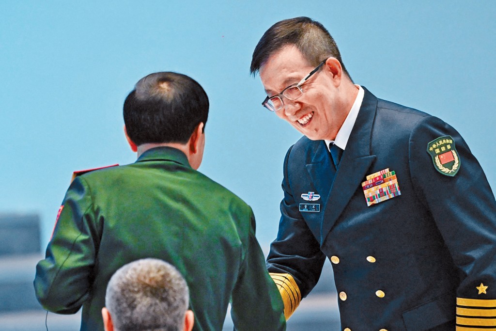 國防部長董軍在香山論壇同外國代表握手。