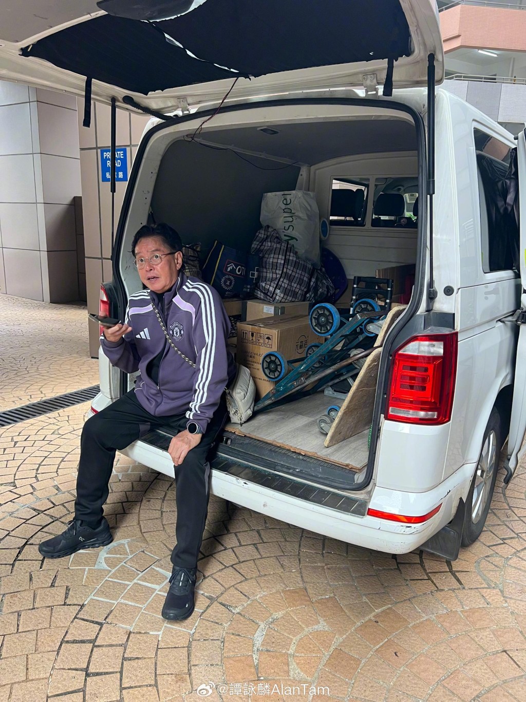譚詠麟坐在貨車尾,逐一通知朋友他會送紅酒上門。 譚詠麟坐在貨車尾,逐一通知朋友他會送紅酒上門。