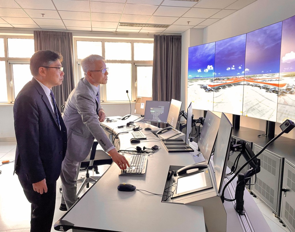 林世雄（左）昨日參觀北京大興國際機場，聽取有關桌面塔台模擬機室的介紹。