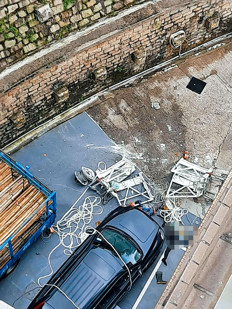 吊船由二十楼堕街断为两截，两工人倒地，当场惨死。