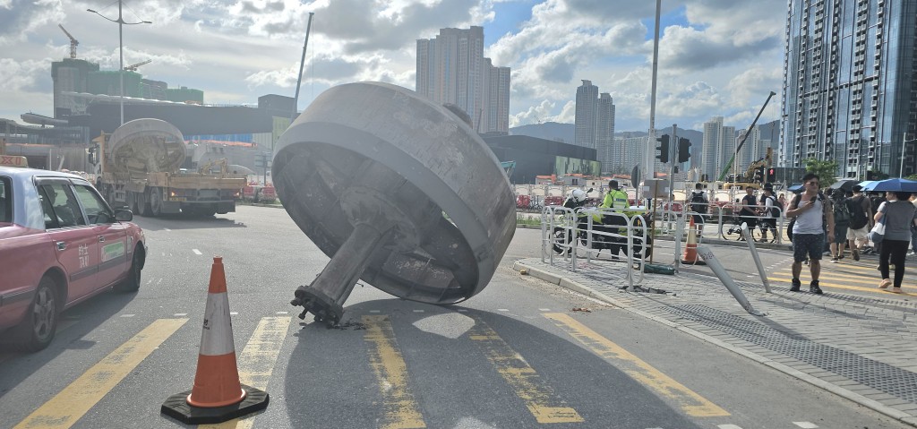 一個巨型金屬輪狀物從貨車上滾至路面，並撞向路邊欄杆。徐裕民攝