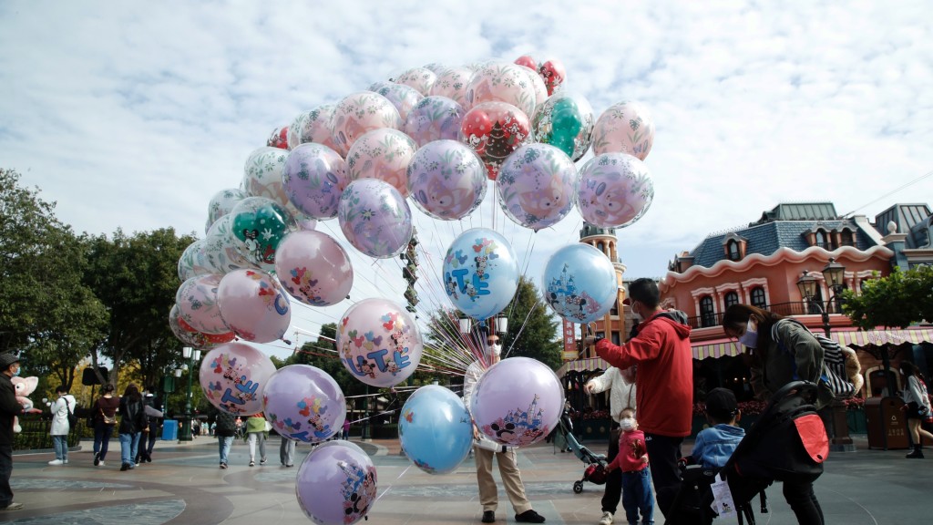 上海迪士尼乐园疫后重开，游客选购气球。 中新社
