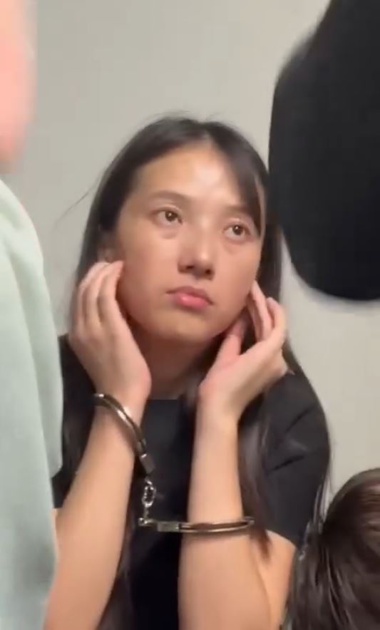 涉嫌殴打大马移民官的中国女游客被锁上手扣。Threads＠rizalhakimm_punyer