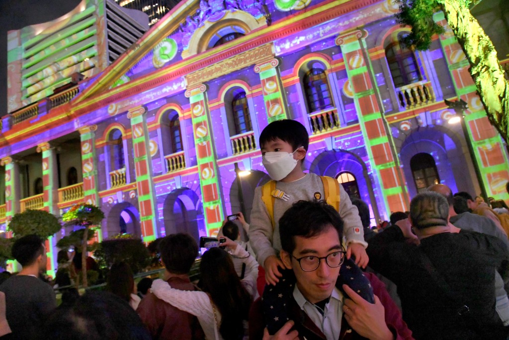 有家長帶同小朋友、有情侶,以及外國遊客等,陸續到場準備觀看由八大地標建築組成的「光影匯.中環」3D投影秀。 有家長帶同小朋友、有情侶,以及外國遊客等,陸續到場準備觀看由八大地標建築組成的「光影匯.中環」3D投影秀。