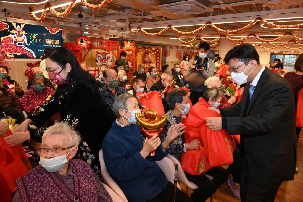 孙玉菡（站立，右一）及刘焱（站立，左一）向长者送上贺年福袋。政府新闻处图片