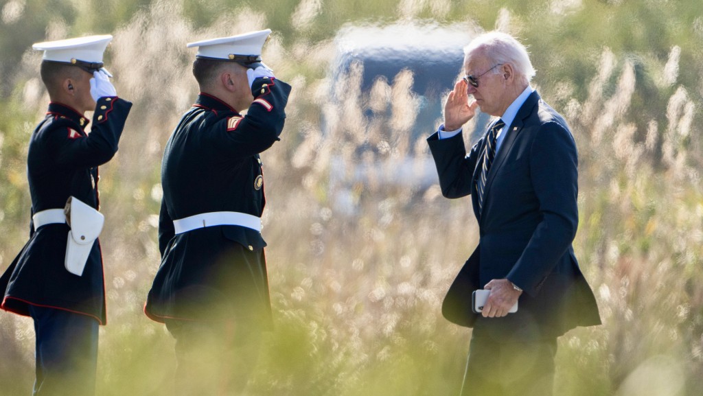 美国总统拜登登上海军陆战队一号时向仪仗队致敬。 美联社