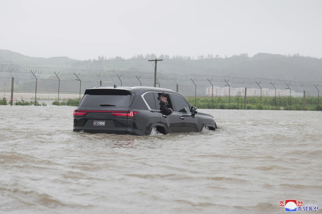 金正恩视察现场时乘坐的大型SUV车四个车轮，都被水淹没。美联社
